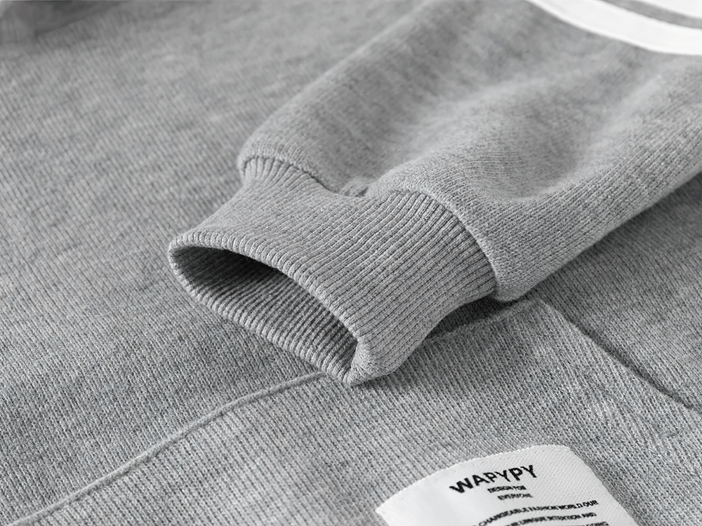 Gray fleece-lined kid's hoodie sleeve with white stripe detail, showcasing ribbed cuff and cozy design for winter comfort and style.